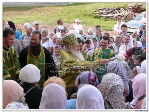 Архиепископ Никон окропляет святой водой прихожан.